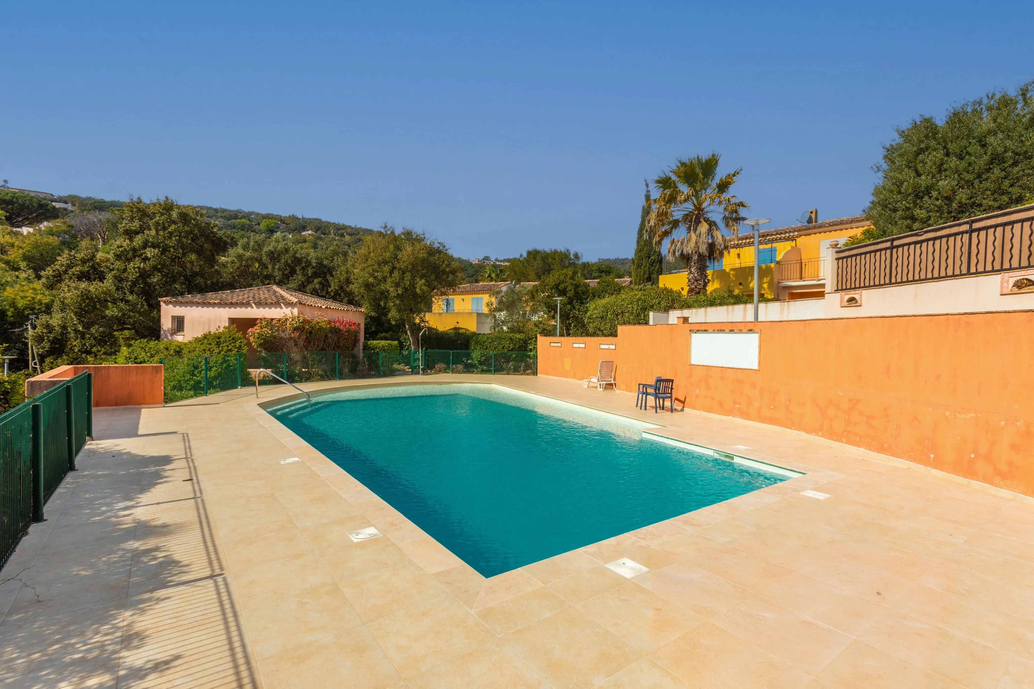 Piscine calme de la résidence bordée de végétation